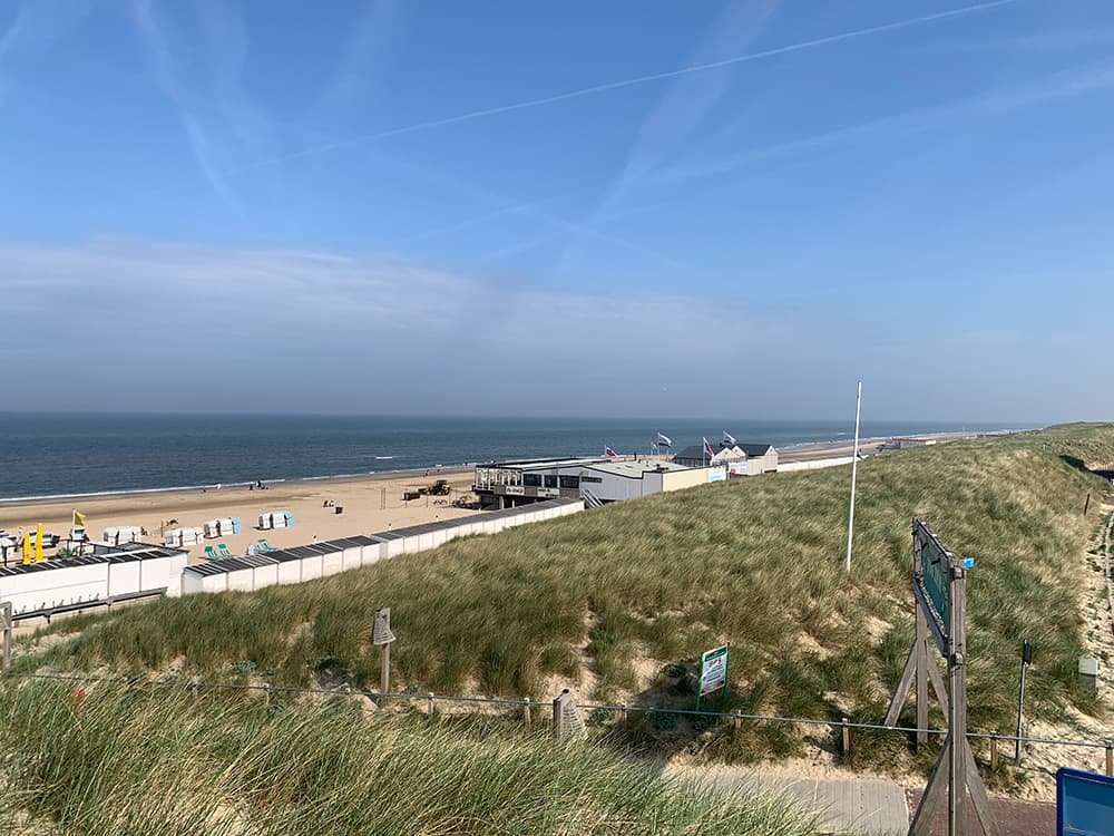 Strandopgang met strandtent aan Zee in badplaats in Noord-Holland