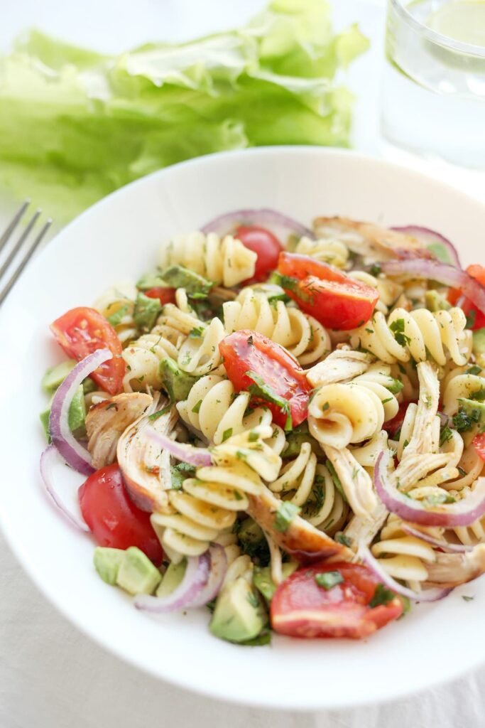 Koude pastasalade met kip, avocado, tomaatjes en een frisse dressing