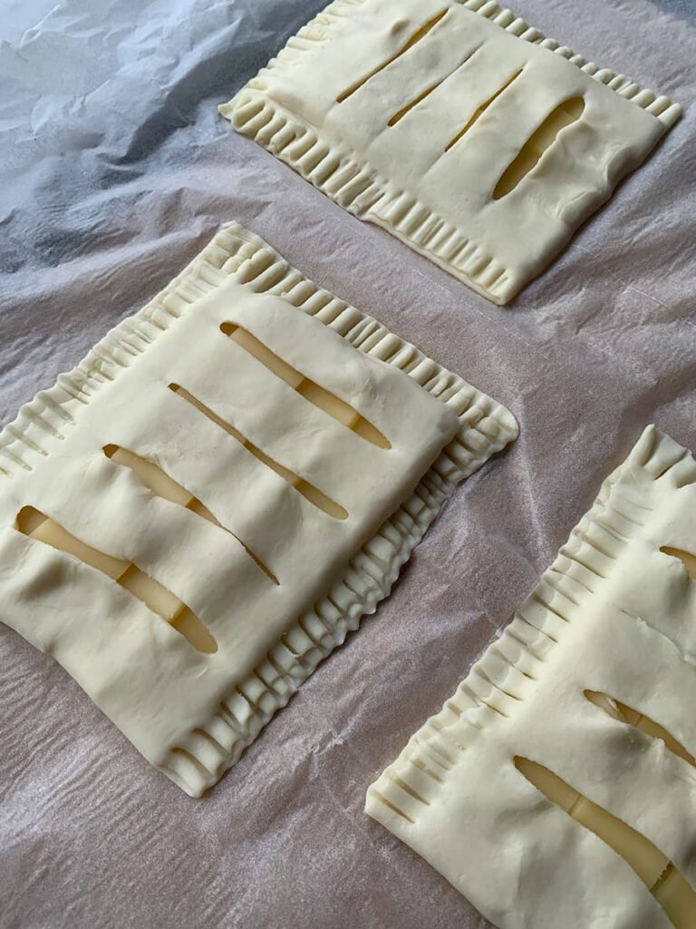 Bladerdeeg kaasbroodjes met roomkaas en oude kaas dichtvouwen