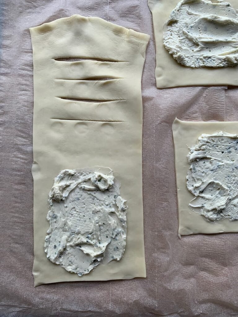 Bladerdeeg kaasbroodjes met roomkaas insmeren