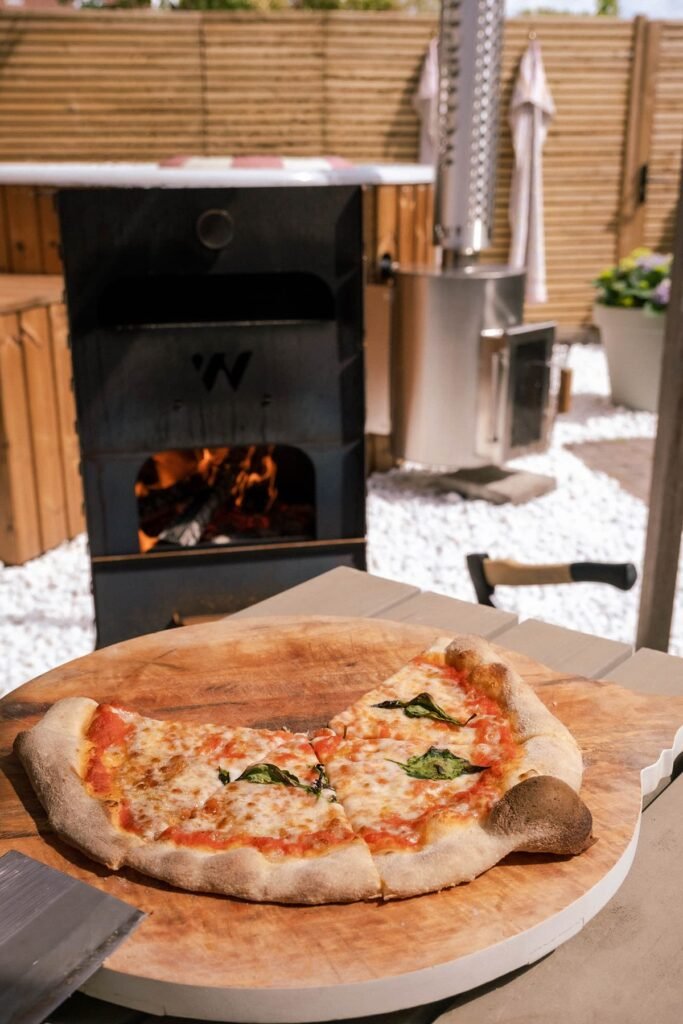 Pizza bakken in de houtgestookte pizzaoven van Welvaere