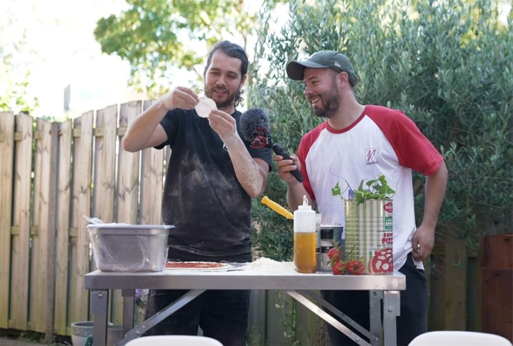 Fratelli e pizza tijdens het bereiden van de pizza met salami