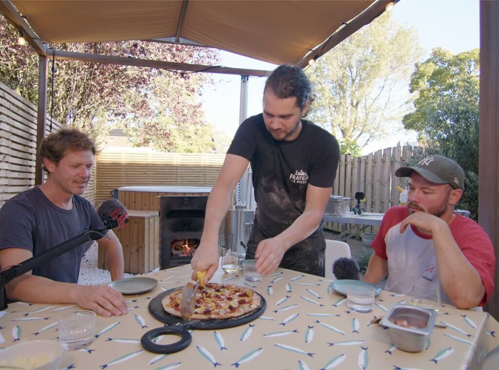 Pizza met Salami en 'Nduja wordt aangesneden tijdens de podcast