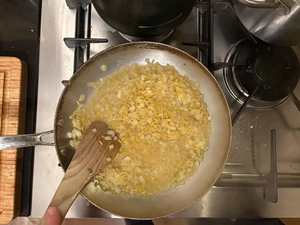 Blijf roeren en bouillon toevoegen totdat de orzo gaar is